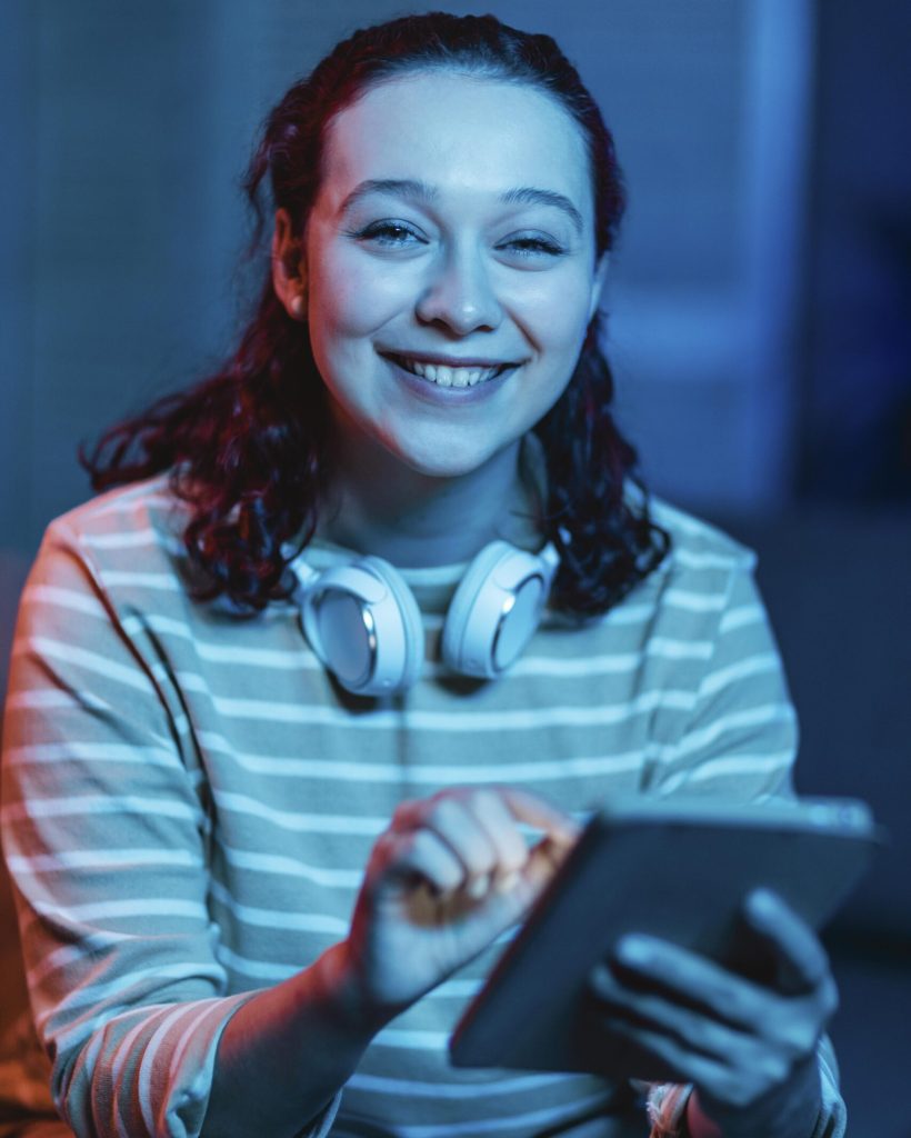 front-view-smiley-woman-home-using-headphones-tablet